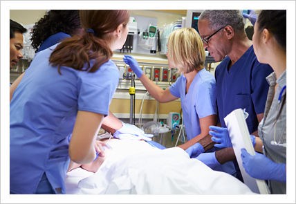 This is a picture of doctors and nurses standing around a patient in a er setting