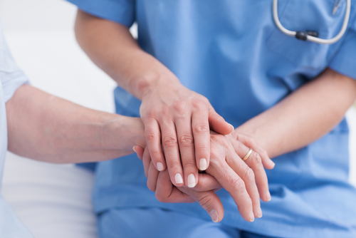 This is a picture of a nurse holding a patients hand
